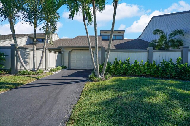 view of front of property with a garage and a front lawn