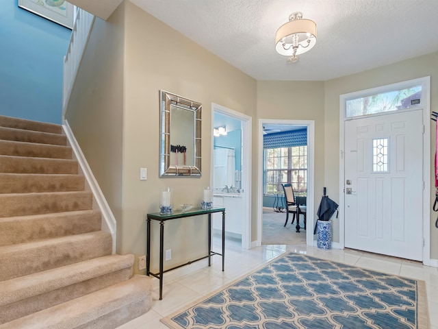 entrance foyer featuring tile patterned floors, plenty of natural light, and a textured ceiling