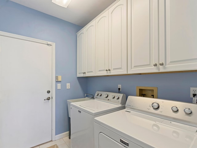 laundry area featuring cabinets, light tile patterned floors, and separate washer and dryer