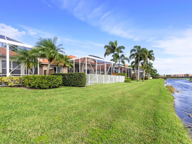 view of yard with a lanai and a water view