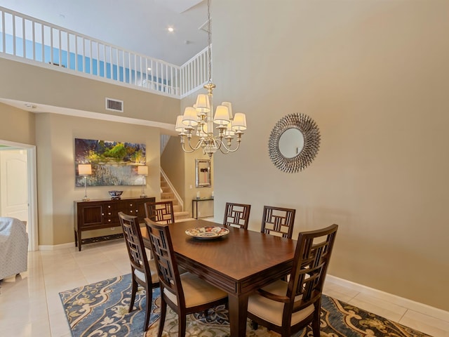 dining space featuring a chandelier, light tile patterned floors, and a high ceiling