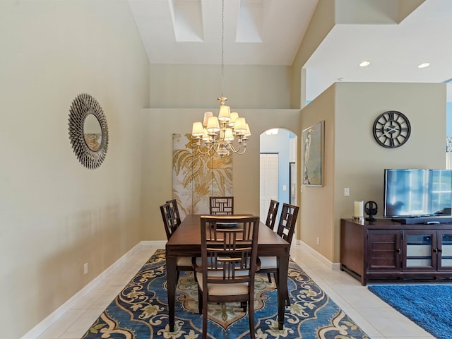 dining room with light tile patterned floors, high vaulted ceiling, and a notable chandelier