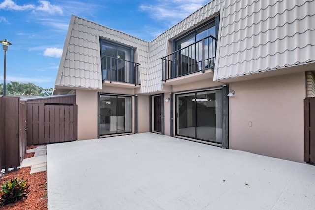 rear view of house featuring a patio area and a balcony