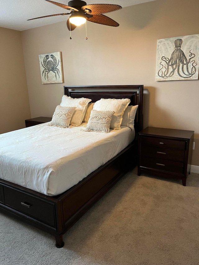 carpeted bedroom featuring ceiling fan and a textured ceiling