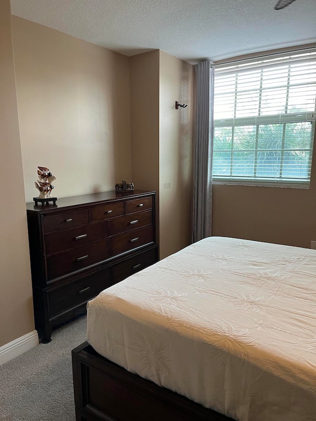 carpeted bedroom featuring a textured ceiling