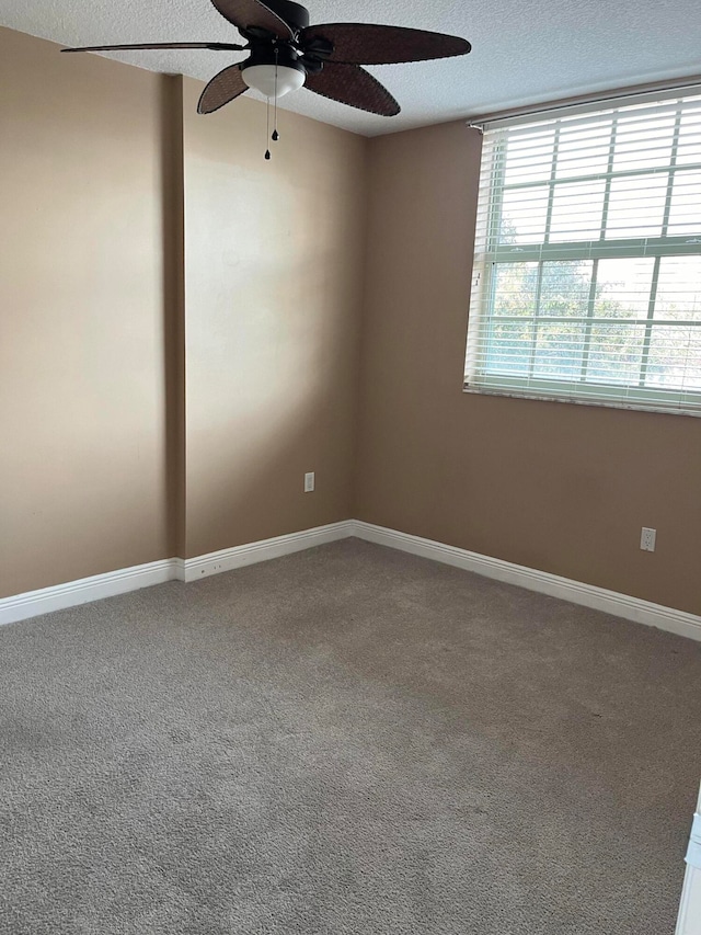 carpeted empty room featuring a textured ceiling and ceiling fan