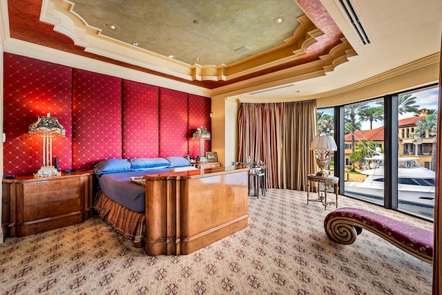 bedroom with access to outside, a tray ceiling, and ornamental molding