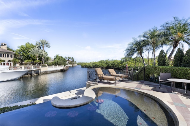 view of pool featuring a patio area and a water view