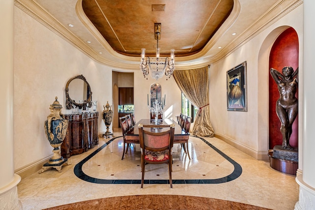 dining space featuring a raised ceiling, crown molding, and a chandelier