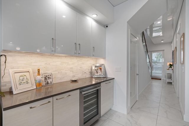 bar featuring backsplash, wine cooler, and dark stone countertops