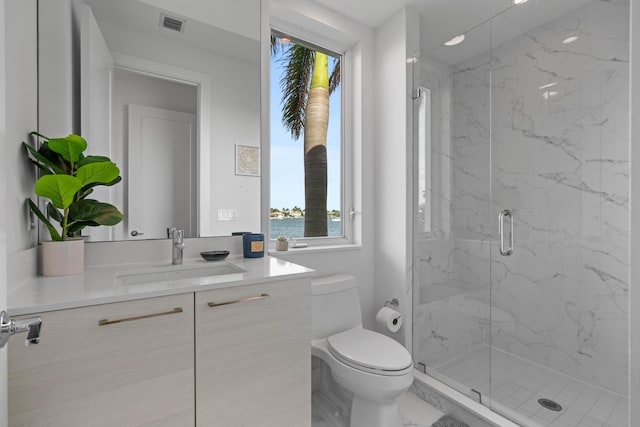 bathroom with a shower with door, vanity, and toilet