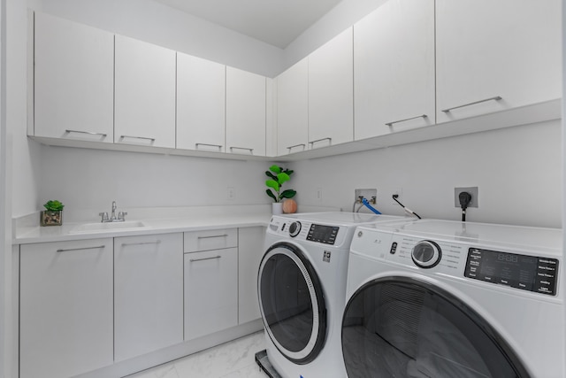 laundry room featuring cabinets, washing machine and dryer, and sink