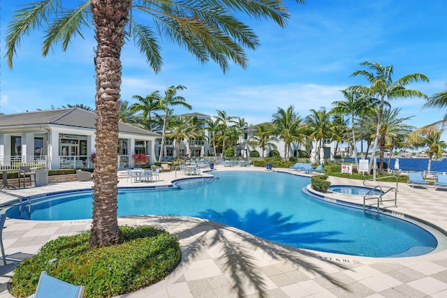 view of pool featuring a community hot tub and a patio