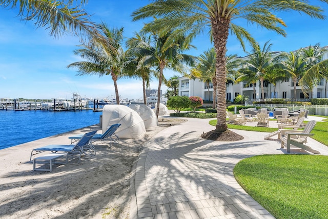 surrounding community featuring a water view and a dock