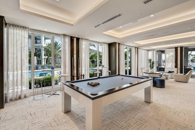 game room with a tray ceiling and billiards