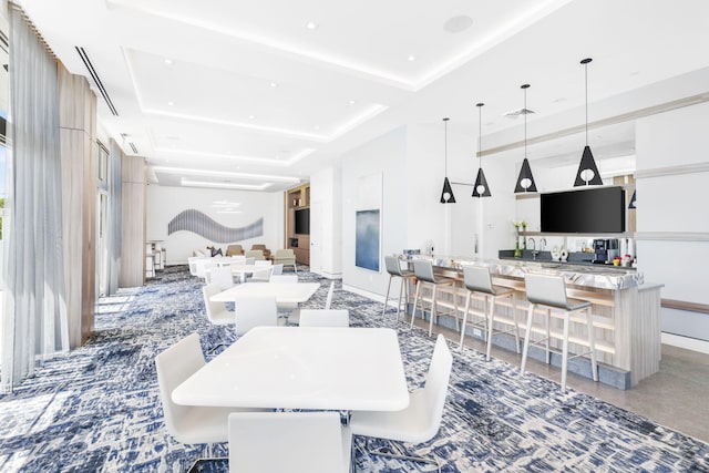 dining space featuring concrete flooring and a raised ceiling