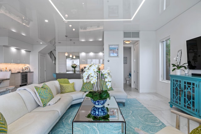 living room featuring a high ceiling and beverage cooler