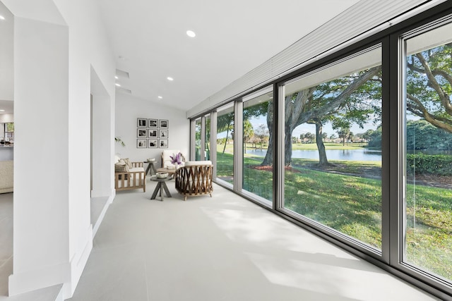 sunroom / solarium with a water view and lofted ceiling