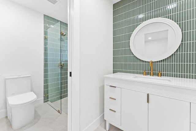 bathroom with a tile shower, tile patterned flooring, vanity, and toilet