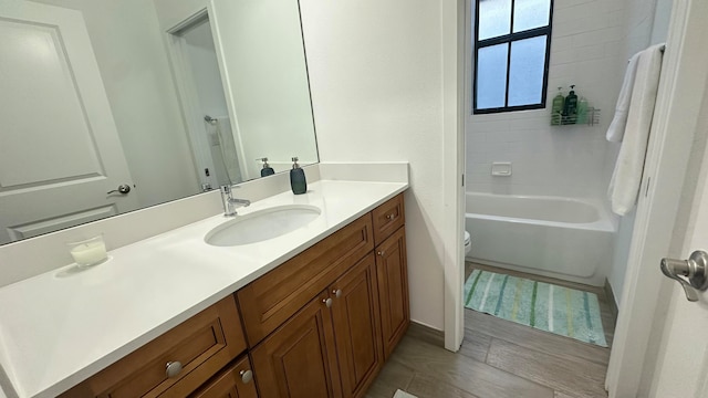 full bathroom featuring hardwood / wood-style floors, vanity, toilet, and tub / shower combination