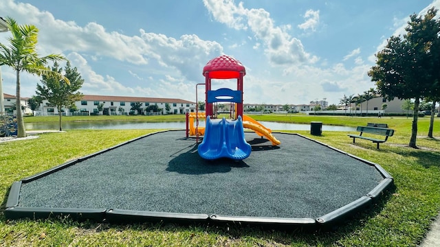 view of play area with a yard and a water view