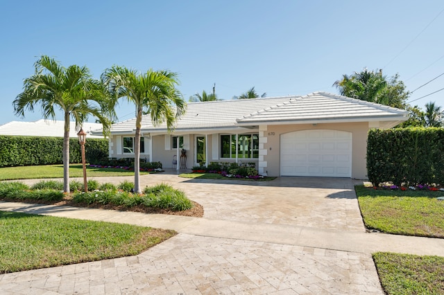 ranch-style home with a garage and a front lawn