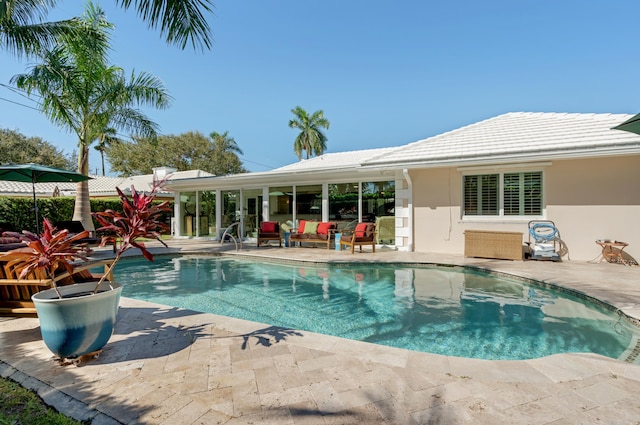 view of pool featuring outdoor lounge area and a patio