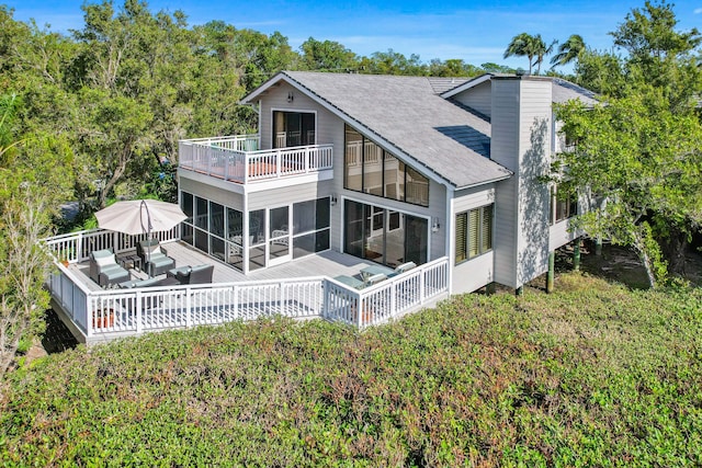 rear view of property with a sunroom and an outdoor living space