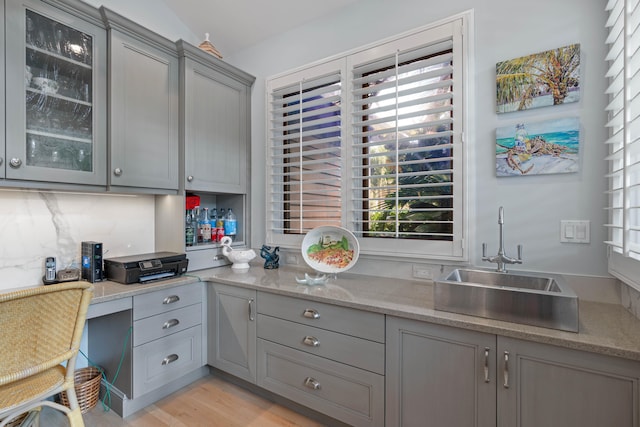 kitchen featuring sink, light wood-type flooring, a healthy amount of sunlight, and gray cabinetry