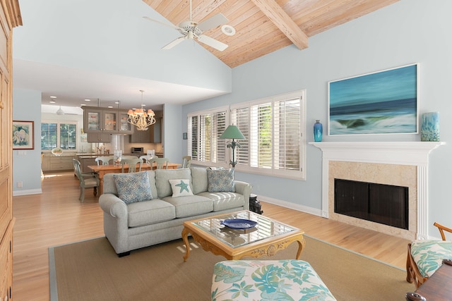 living room with wooden ceiling, high vaulted ceiling, ceiling fan with notable chandelier, beam ceiling, and light hardwood / wood-style floors