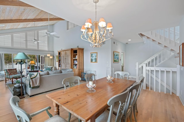 dining space featuring beamed ceiling, ceiling fan with notable chandelier, light hardwood / wood-style floors, and high vaulted ceiling