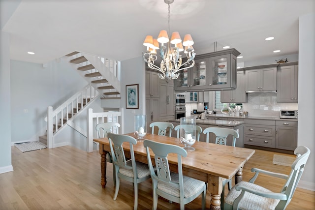 dining room featuring light wood-type flooring and an inviting chandelier