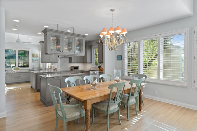 dining room featuring sink, light hardwood / wood-style floors, and a notable chandelier