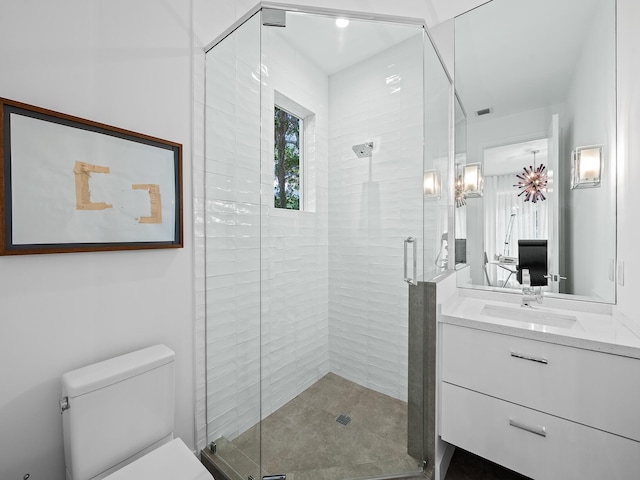 bathroom featuring vanity, an enclosed shower, and toilet