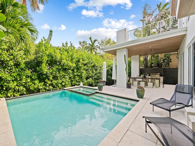 view of swimming pool featuring a bar, a patio, and an in ground hot tub