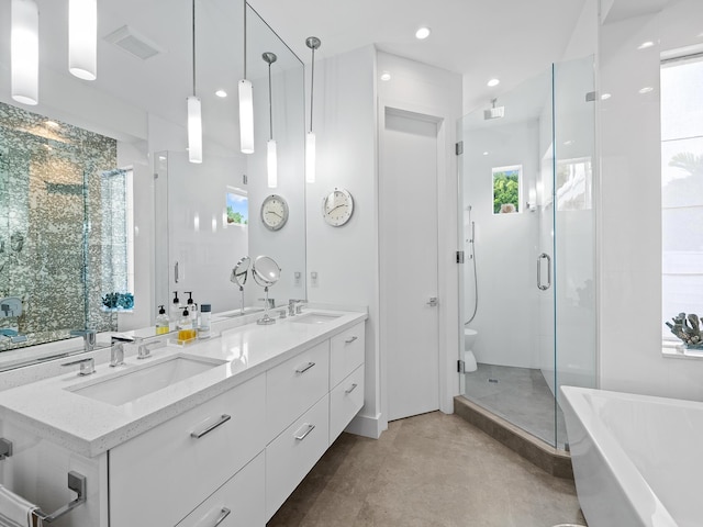 bathroom with vanity, concrete flooring, plus walk in shower, and a healthy amount of sunlight