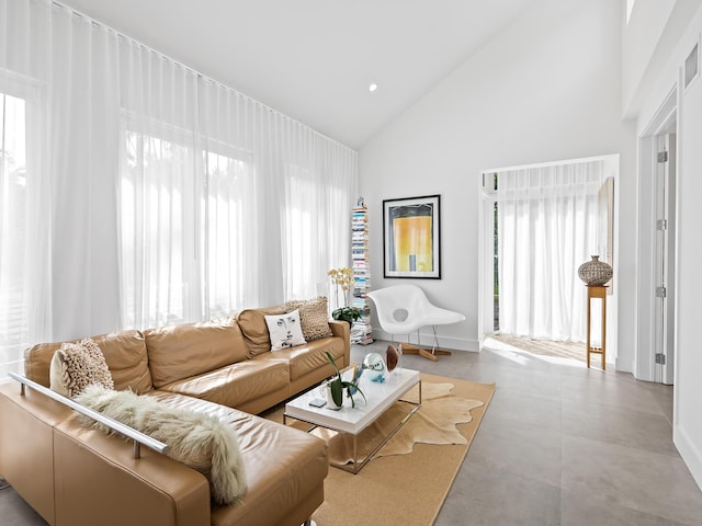 living room featuring high vaulted ceiling and a healthy amount of sunlight