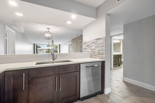 kitchen with pendant lighting, dishwasher, an inviting chandelier, sink, and light hardwood / wood-style flooring