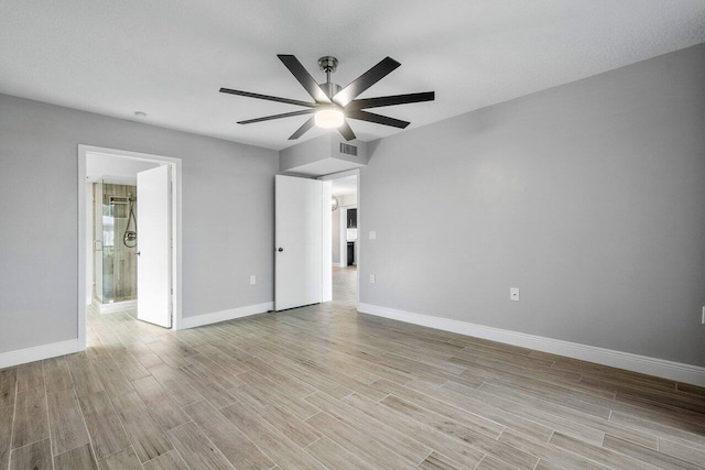 empty room with ceiling fan, light hardwood / wood-style floors, and a textured ceiling