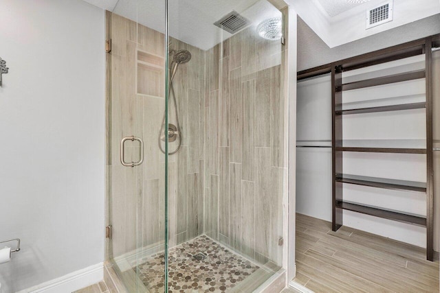 bathroom featuring a shower with door and a textured ceiling