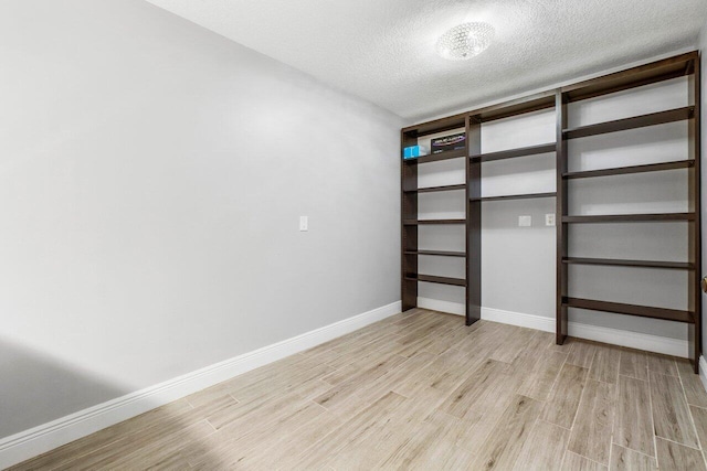 unfurnished bedroom with a closet, a textured ceiling, and light wood-type flooring