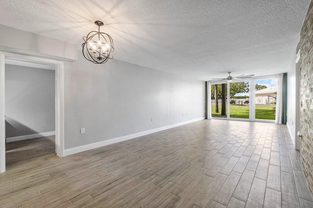 unfurnished room with ceiling fan with notable chandelier, hardwood / wood-style floors, and a textured ceiling