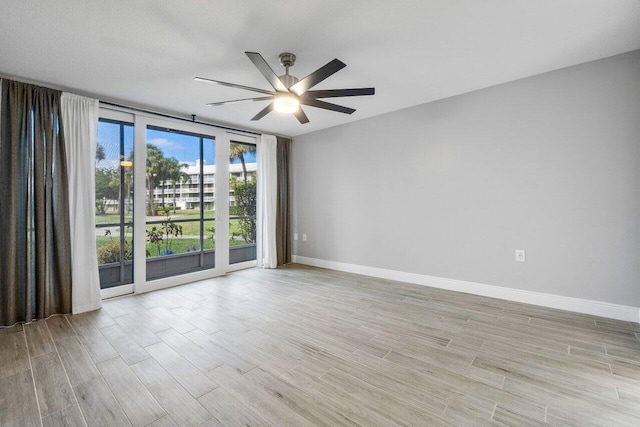 spare room with ceiling fan and light wood-type flooring