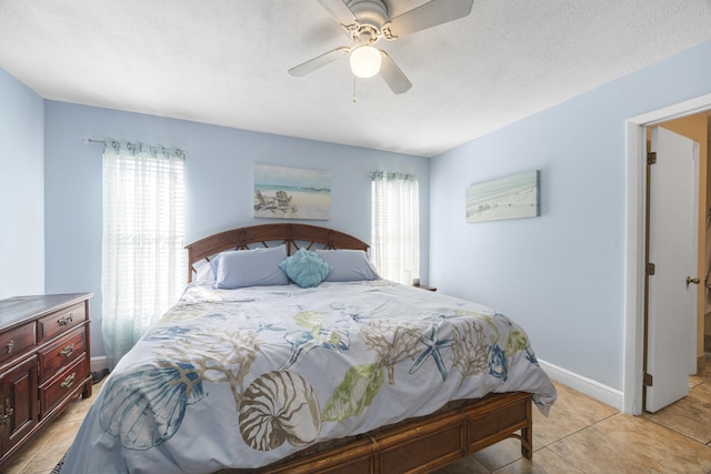 tiled bedroom with ceiling fan and a textured ceiling