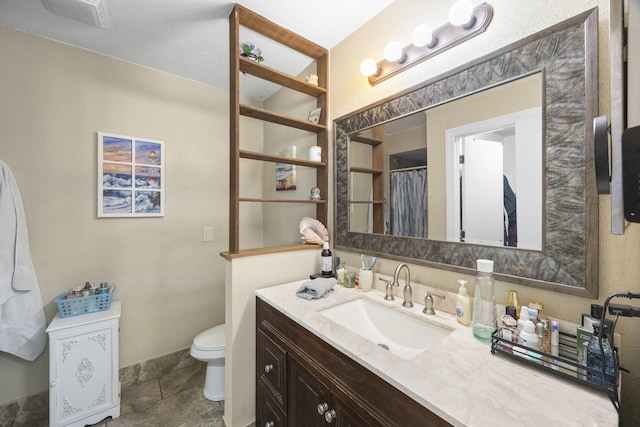 bathroom featuring toilet, vanity, and tile patterned floors