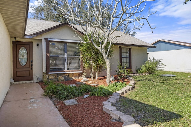 view of exterior entry featuring a lawn