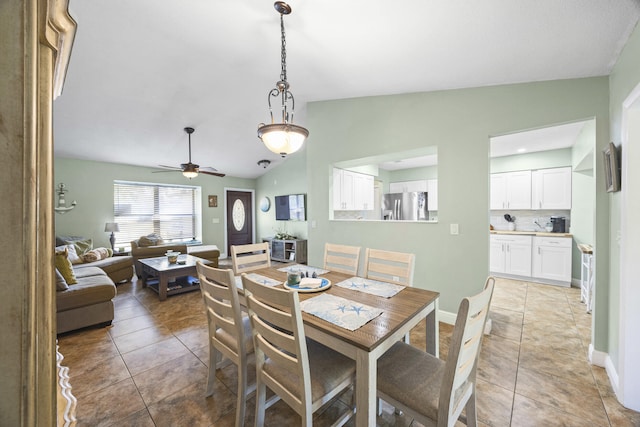 tiled dining area with ceiling fan and lofted ceiling