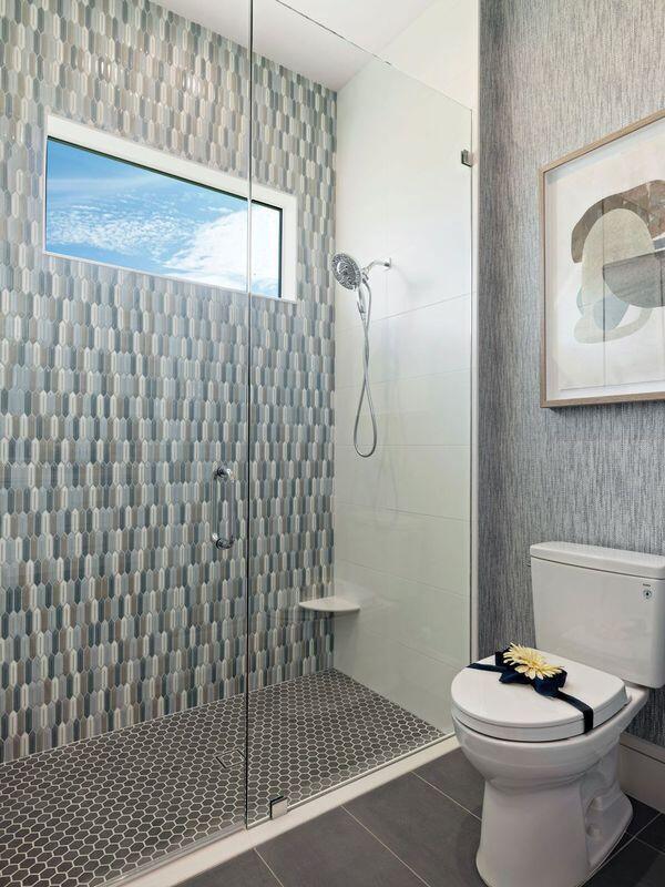 bathroom featuring tile patterned floors, toilet, and tiled shower