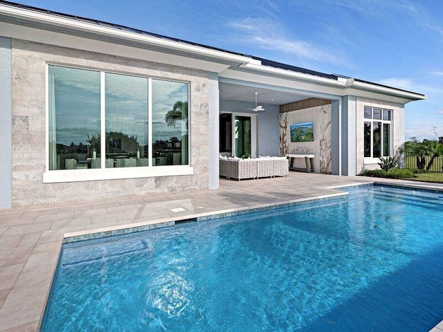 view of swimming pool with outdoor lounge area, ceiling fan, and a patio