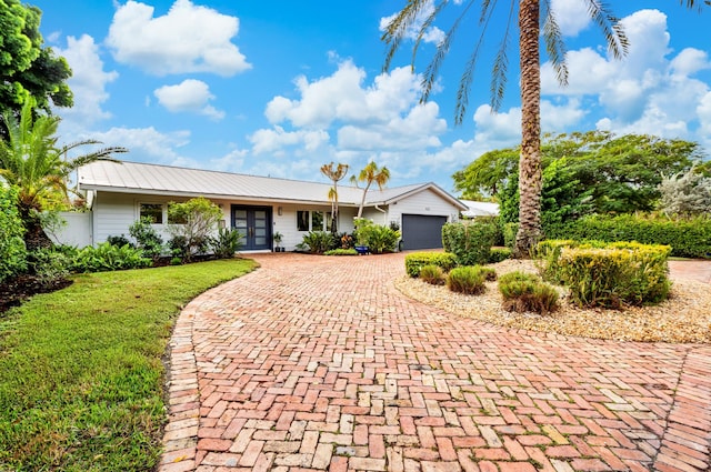 single story home featuring french doors, a front yard, and a garage